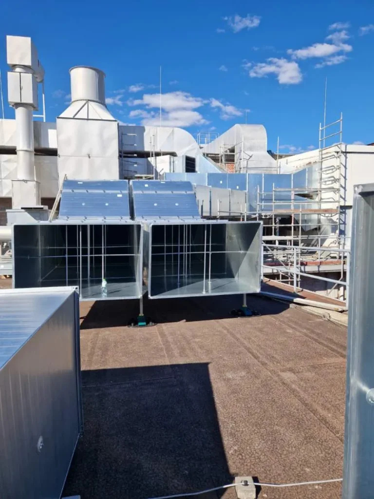 Wentylacja przemysłowa, montaż kanałów wentylacyjnych, instalacje klimatyzacyjne na dachu budynku.